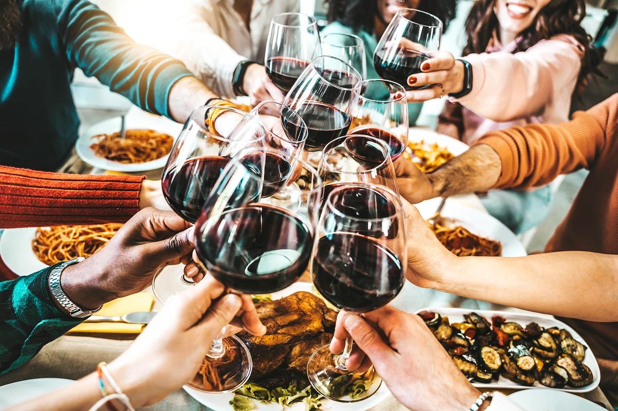 Friends toasting with red wine at dinner.
